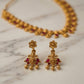 Gold earrings with red stones on a marble surface