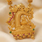 Gold pendant with intricate design and gemstones on a beige background