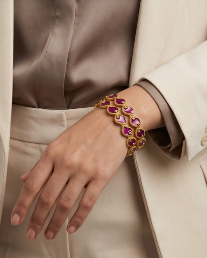 Bracelet with pink gemstones on a person wearing a beige coat