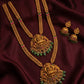 Gold necklace with green beads and matching earrings on a dark fabric background