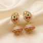 Gold earrings with gemstones on a beige fabric background