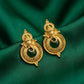 Gold earrings with black stones on a green fabric background