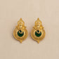 Gold earrings with green gemstones on a beige background