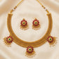 Gold necklace with matching earrings on a beige fabric background