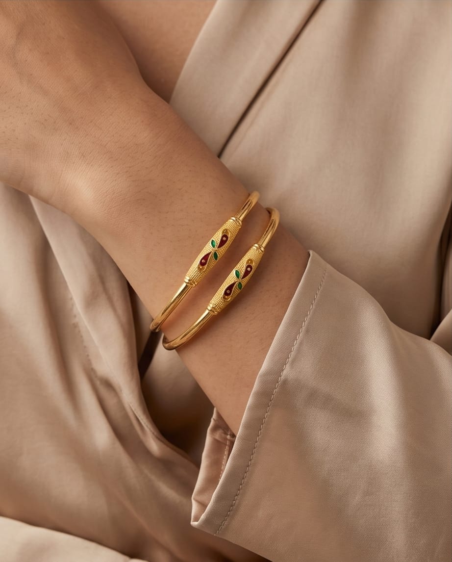Gold bracelet with embedded stones on a beige background