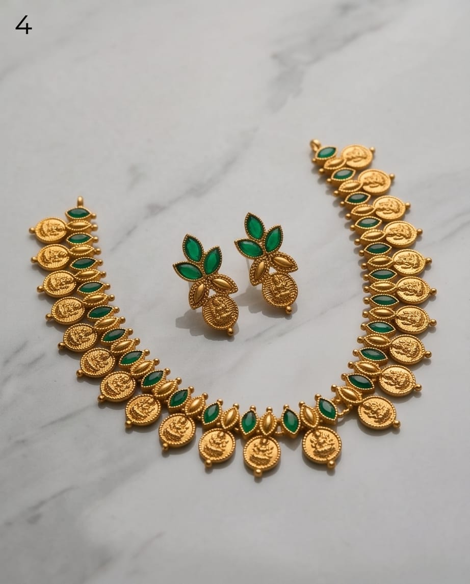 Gold and green jewelry set on a marble surface