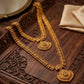 Gold necklace with intricate designs on a wooden surface