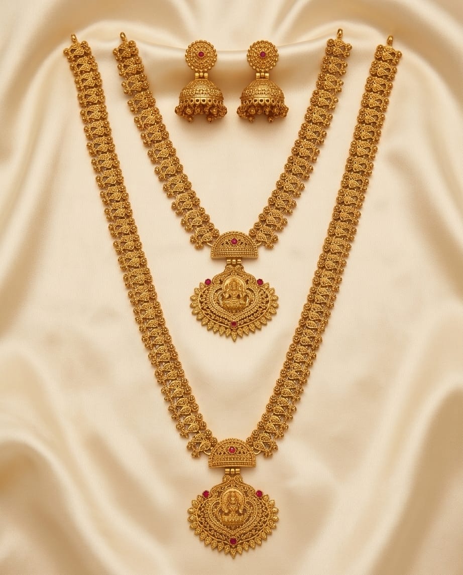 Gold necklace and earrings set on a beige fabric background