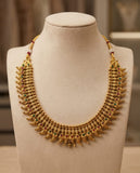 Gold necklace with gemstones on a mannequin bust