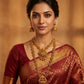 Woman wearing traditional jewelry and a saree with a warm background