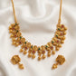 Gold necklace with intricate design on a white fabric background