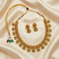 Gold necklace and earrings set on a beige fabric background