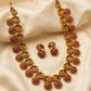 Gold necklace with red gemstones on a beige fabric background