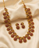 Gold necklace with red gemstones on a beige fabric background
